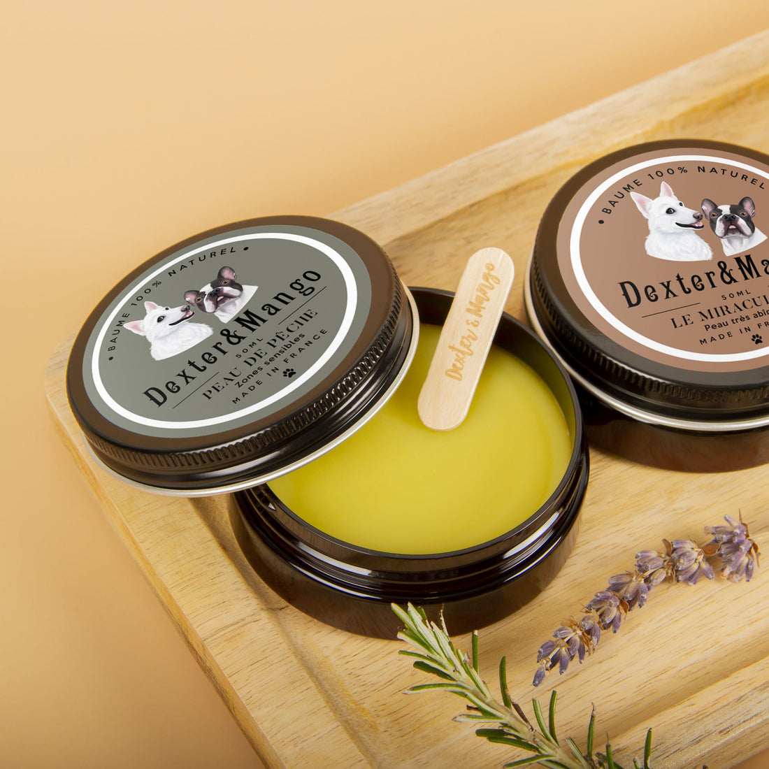 Baumes Peau de Pêche et Le Miraculeux Dexter et Mango ouverts sur une planche en bois avec spatule en bois et plantes séchées